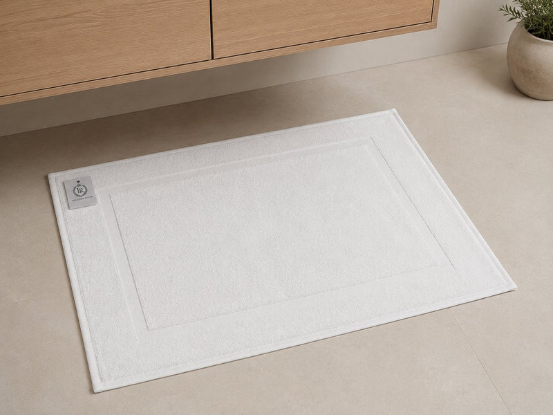Witte katoenen badmat 50x70 cm 650 GSM op de badkamervloer