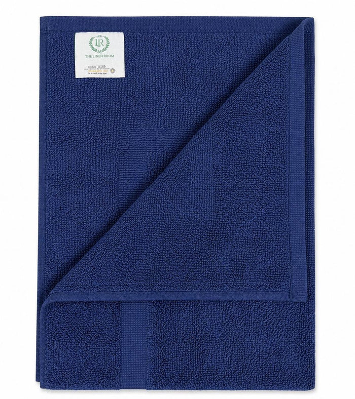 Opgevouwen donkerblauwe badmat 50x70 cm met label van The Linen Room